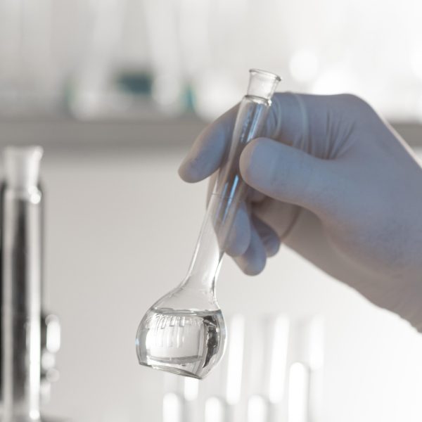 close-up-hand-holding-lab-glassware